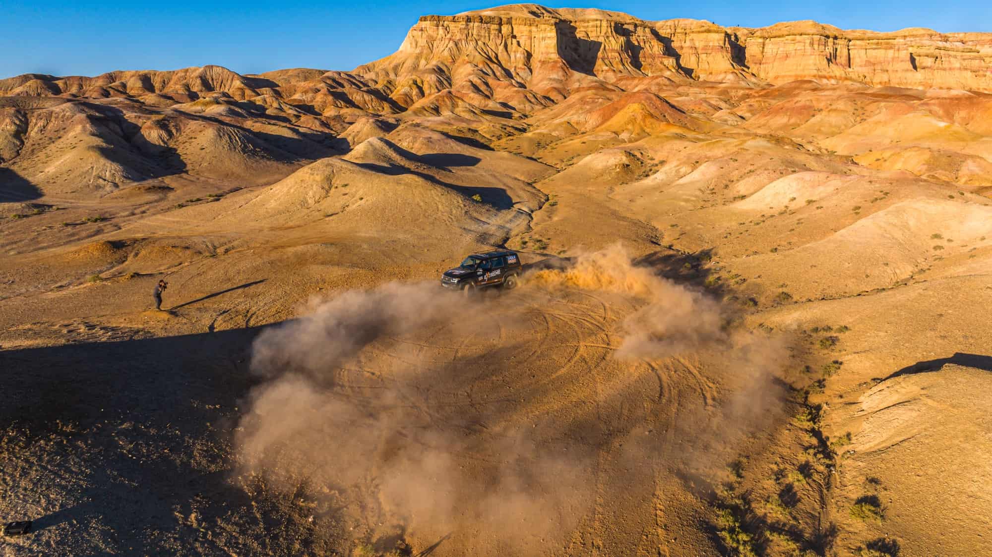 a car on an offroad Mongolia tour driving through a desert
